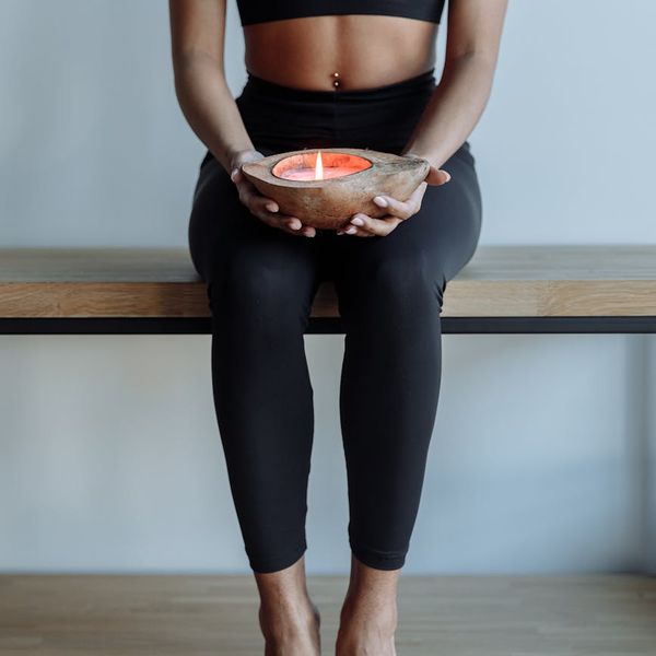 Person sitting cross-legged in meditation, surrounded by calm atmosphere.
